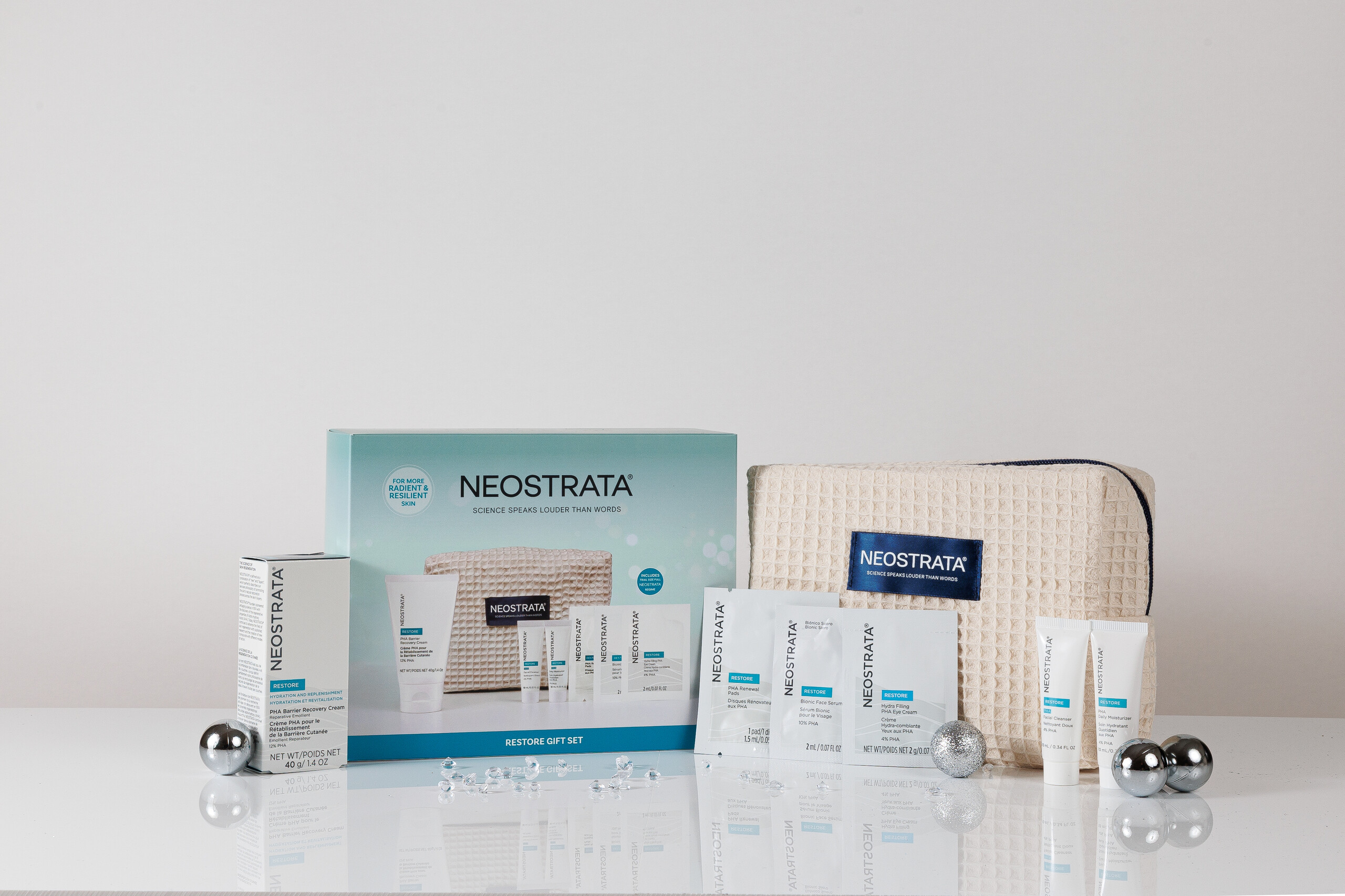 NEOSTRATA Restore Gift Set contents and cream beauty bag with silver baubles