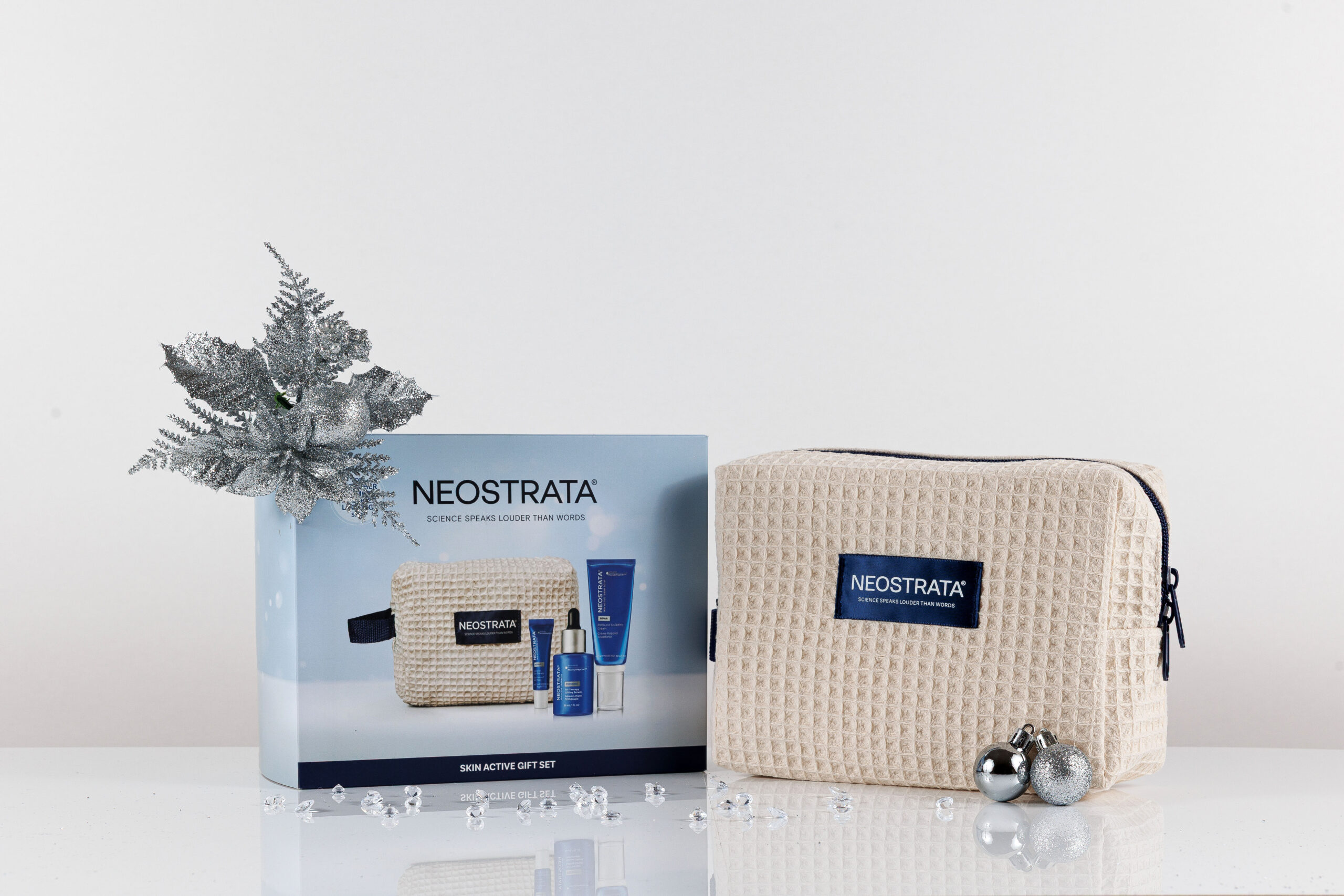 NEOSTRATA Skin Active Gift Set box beside its cream beauty bag and Christmas decorations
